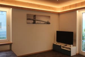Gemütliches Wohnzimmer mit Fernseher, Brooklyn-Bild und großen Fenstern.
