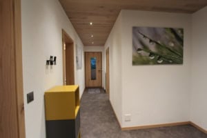Moderne Hausflur mit Wanddekoration und gelber Ablage.