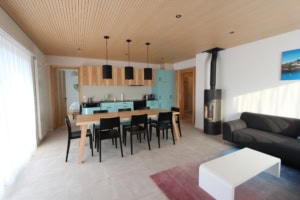 Helle, moderne Küche mit Essbereich und Kamin im Wohnzimmer.