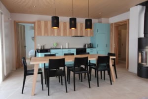 Zeitgenössische Küche mit Holz- und Blautönen, Essbereich und Kamin.