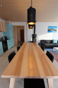 Geräumiges Esszimmer mit Holzdecke, moderner Tisch und Kamin.
