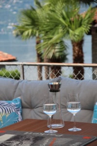 Balkon mit Wasserblick, Wasser, Palmen und Sitzbereich.