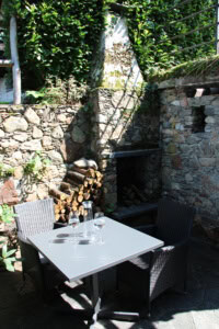 Gemütlicher Außenbereich mit Tisch, Stühlen und Gartenmauer bei DreamView.