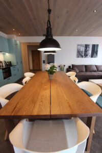 Elegantes Esszimmer mit Holzdecke, Esstisch und moderner Einrichtung.