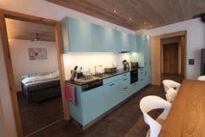Helle, moderne Küche mit blauen Schränken und Küchenutensilien.