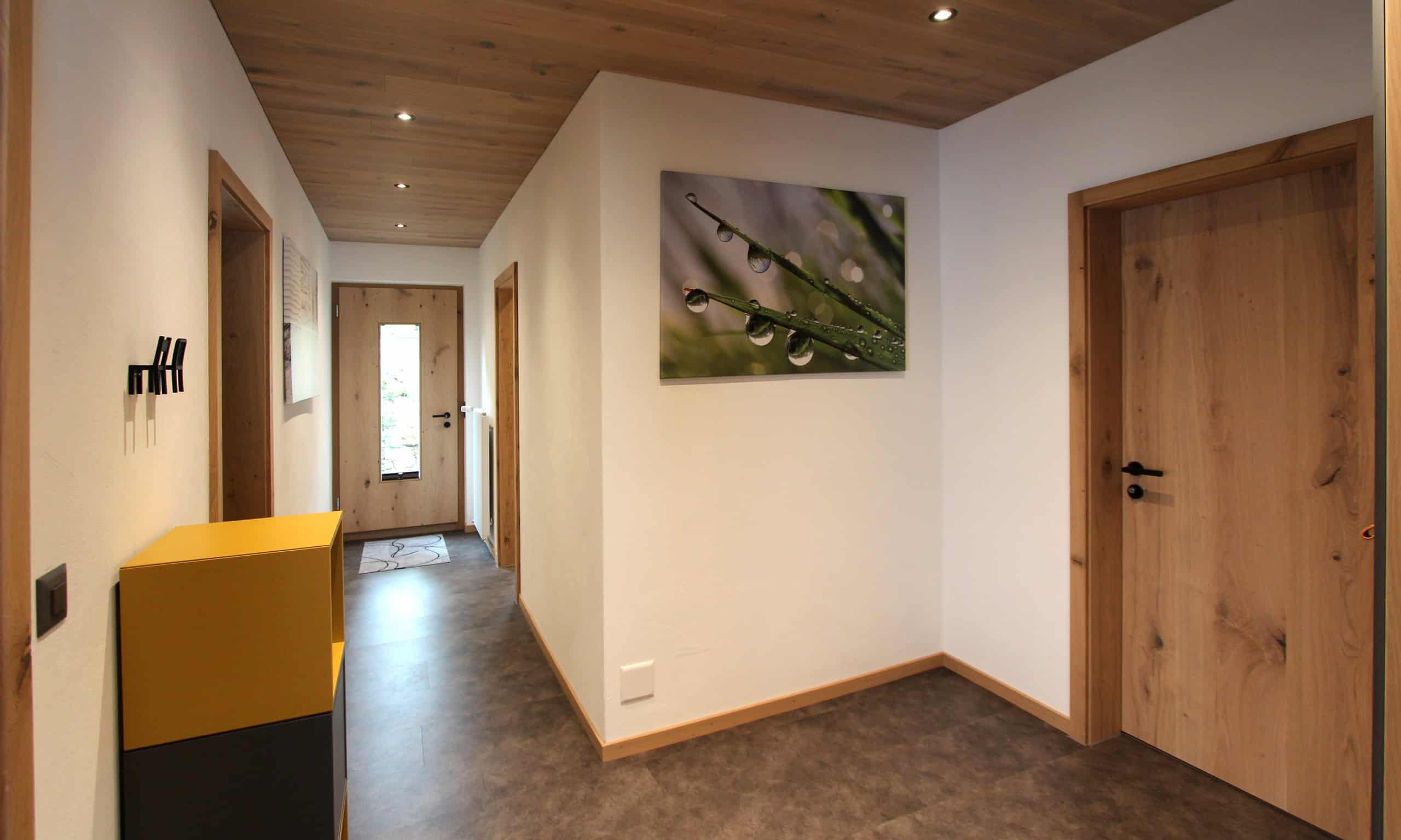 Heller Flur mit Naturbild und Holztüren in modernem Design.